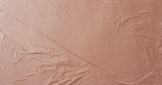 Video of close up of beige creased fabric with copy space