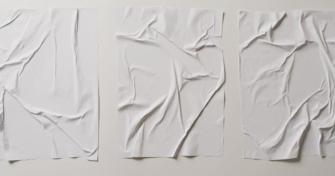 Video of close up of three pieces of white creased fabric with copy space
