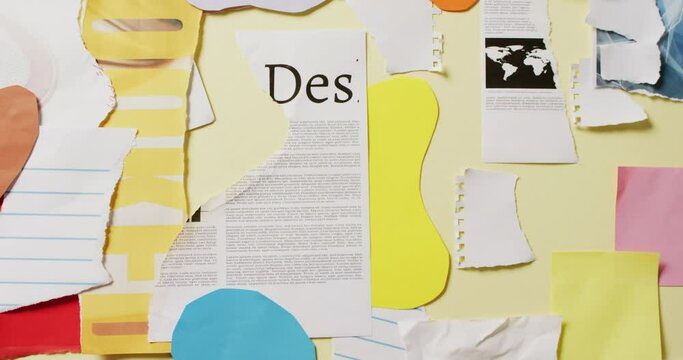 Video of close up of collage of scraps of paper and newspaper on yellow background