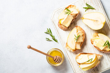 Sweet toast with pear, cheese and honey. Healthy snack or breakfast. Top view with copy space.