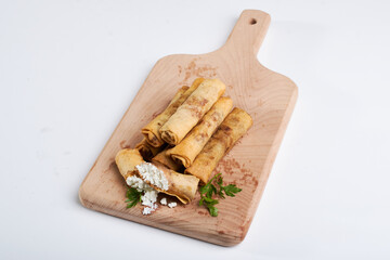 Spring Roll stuffed with white cheese with parsley paper on a piece