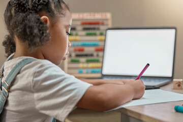 Laptop mockup, online education and elearning with kid, girl and student writing test at table for zoom call lesson. Home school child studying with virtual teaching, technology mock up and internet