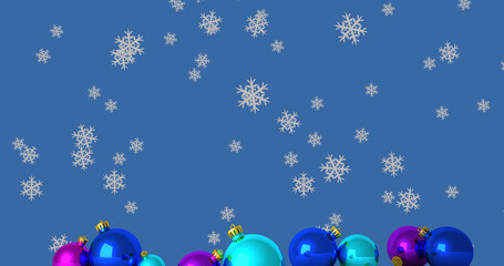 Image of snowflakes falling over christmas baubles on blue background