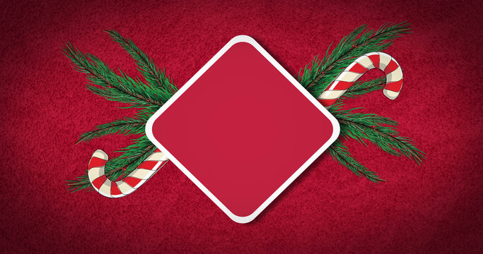 Image of candy canes and fir tree over sign with copy space on red background