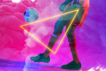 Low section of male player kicking ball with illuminated triangular shape against smoke, copy space