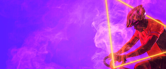 African american male cyclist riding bicycle with illuminated triangle against purple background