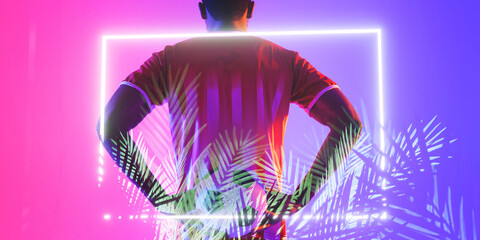 Rear view of african american male soccer player by illuminated plants and rectangle