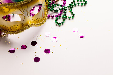 Composition of colourful mardi gras beads and carnival mask on white background with copy space © vectorfusionart