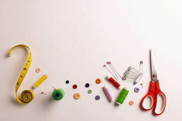 Composition of sewing equipment on white background - Powered by Adobe