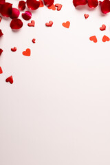 Composition of rose petals and hearts on white background