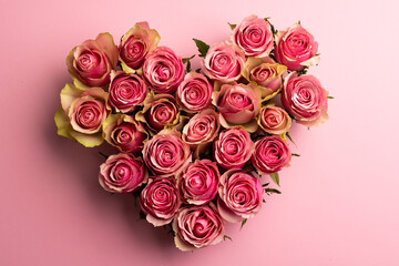 Composition of heart of roses on pink background