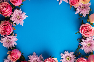 Fototapeta premium Composition of rose wreath on blue background