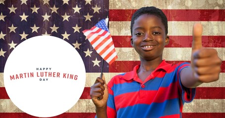 Smiling african american boy with usa flag showing thumbs up by martin luther king jr day
