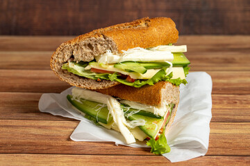 Baguette sandwich. Sandwich with olives, lettuce, tomato, cucumber, cheddar and string cheese on...