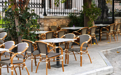 Greek taverna. Photo with tables and wood chairs on a street terrace restaurant from Greece.