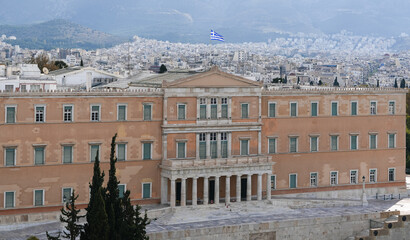 Flag of Greece waving on top of Greek Parliament during a sunny day. Travel to Greece concept photo.