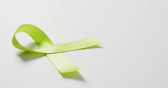 Video of pale green std awareness ribbon on white background with copy space