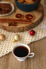 Various Christmas decorations, cup of tea or coffee, sweets, small presents, knitted blanket and candles. Selective focus.
