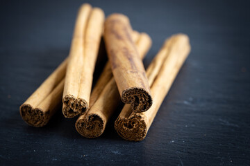 cinnamon sticks on a black background, photographed from the front