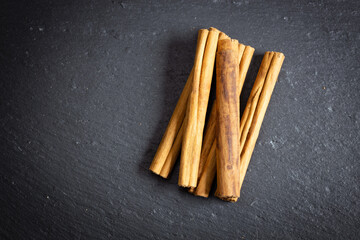 cinnamon sticks on a black background, photographed from the top