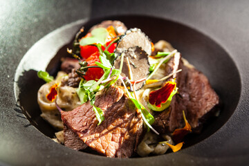Black Angus beef tagliatelle pasta with fresh black truffles and parmegano. Delicious healthy traditional food closeup served for lunch in modern gourmet cuisine restaurant - 552342793