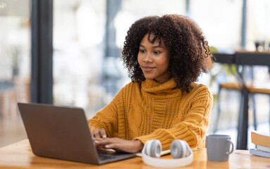 Young beautiful african student girl working, learning in computer and device studying online.