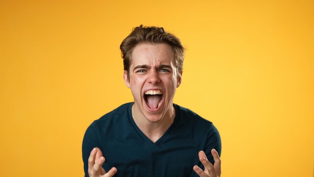 Portrait Of Yelling Angry Frustrated Mad Young Man 20s Isolated Isolated On Yellow Background.