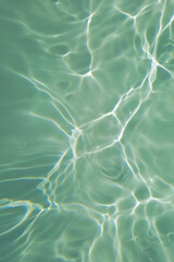 Defocus blurred transparent green colored clear calm water surface texture with splashes and bubbles. Trendy abstract nature background. Water waves in sunlight with copy space. Blue watercolor shine