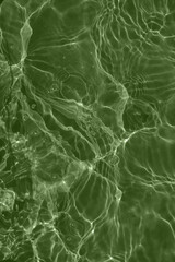 Defocus blurred transparent green colored clear calm water surface texture with splashes and bubbles. Trendy abstract nature background. Water waves in sunlight with copy space. Blue watercolor shine