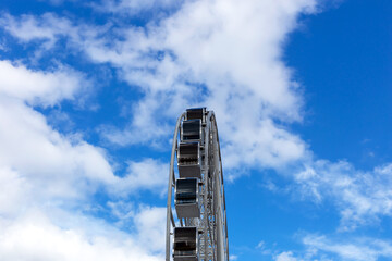 Ferris wheel cabins on the background of the sky and clouds