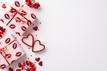 Valentine's Day concept. Top view photo of present boxes in wrapping paper with kiss lips pattern heart shaped candles and confetti on isolated white background with empty space