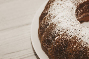 The baked dessert is a round cupcake sprinkled with powder.