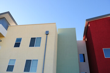 Colorful exterior walls of a modern apartment complex featuring bold stucco finishes in yellow, green, and red tones, illustrating contemporary urban residential architecture and design trends