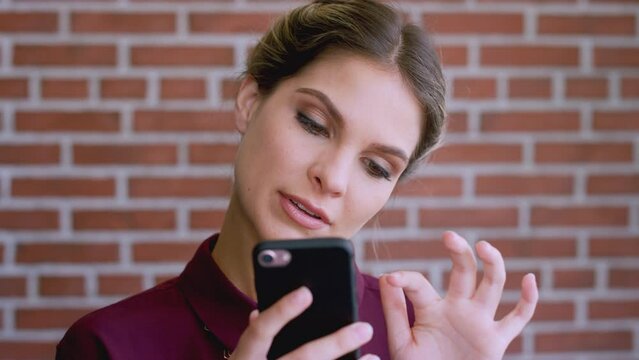 Face, phone and business woman by brick wall on social media, internet browsing or messaging. Wow, tech and amazed female from Canada on mobile smartphone looking at pictures or web scrolling alone.