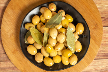 Green olives with cheese filling on a wooden background. Gourmet delicacies. Top view