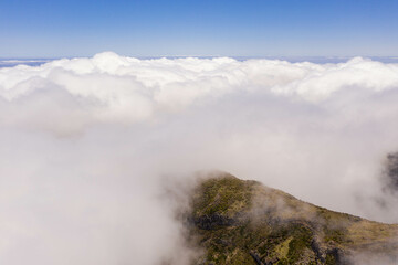 Drone view of mountain peak submerged in fog