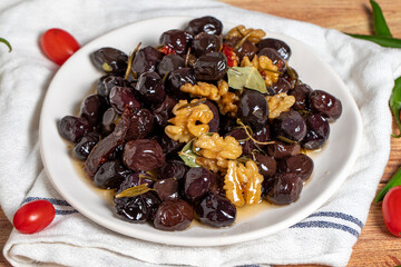 Mixed olives on wood background. Black olives prepared with walnuts and spices. Gourmet delicacies. close up