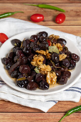 Mixed olives on wood background. Black olives prepared with walnuts and spices. Gourmet delicacies. close up