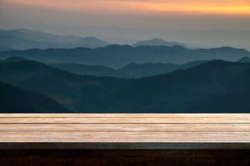 Wooden table top with sunset mountain landscape, for display product.