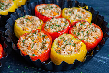 Stuffed pepper. Stewed pepper  with rice and minced meat. Baked peppers in a cast iron pan on a black background. Healthy Romanian food.