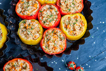 Stuffed pepper. Stewed pepper  with rice and minced meat. Baked peppers in a cast iron pan on a black background. Healthy Romanian food.