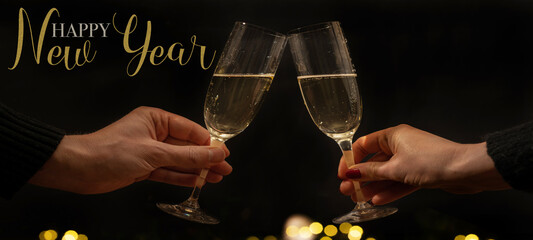 Happy new Year - Toast with sparkling wine or champagne glasses on dark black night background with...