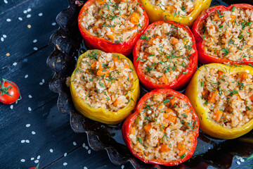 Stuffed pepper. Stewed pepper  with rice and minced meat. Baked peppers in a cast iron pan on a black background. Healthy Romanian food.