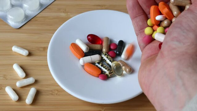 Eating too much medicine, Dietary supplements, Hypochondria, Spilling a handful of colored pills on a plate