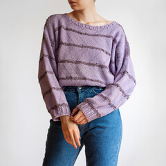 Woman wearing oversized purple sweater and blue mom jeans isolated on white background	