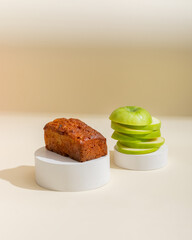Creative serving of apple cake with green apple close up on beige background