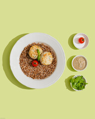 Diet boiled buckwheat with chicken cutlets tomatoes and basil top view on healthy green background close up