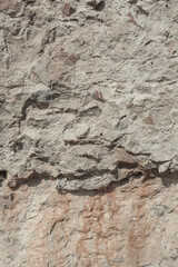 An old weathered wall. Plastered stone surface with rocks. Grunge texture background.