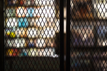 Iron grating door background. Taken from a dark corner inside the shop.