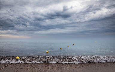 Row of buoys on the ocean against stormy sky